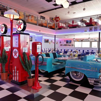 American Diner restaurant with classic cars, gas pump and retro diner furniture